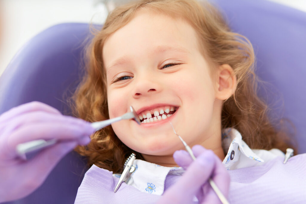dentist examining a happy child's teeth