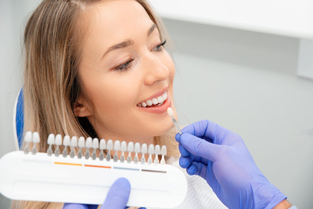 dentist matching tooth shade for a patient