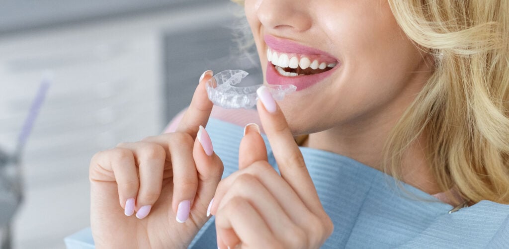 woman putting in a clear dental aligner